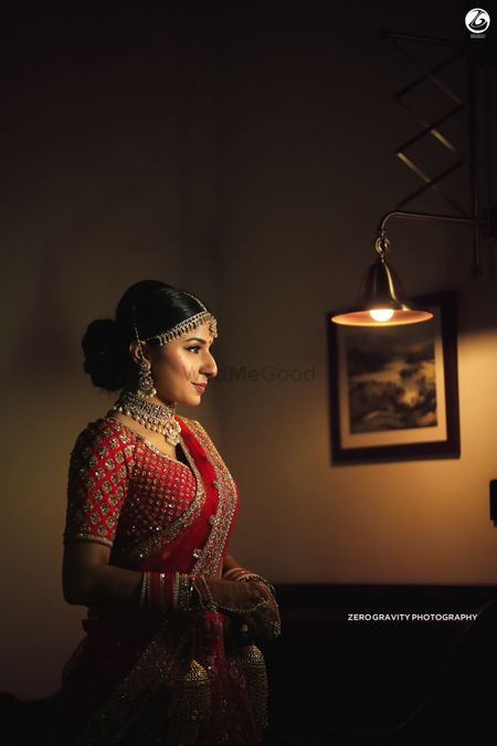 Bridal room portrait with bride wearing red 