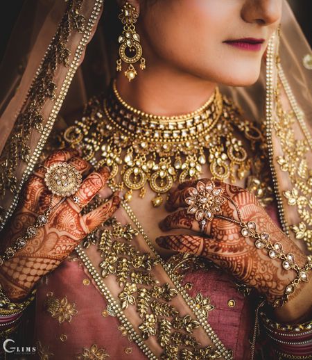 A bride in onion pink lehenga with gold jewellery