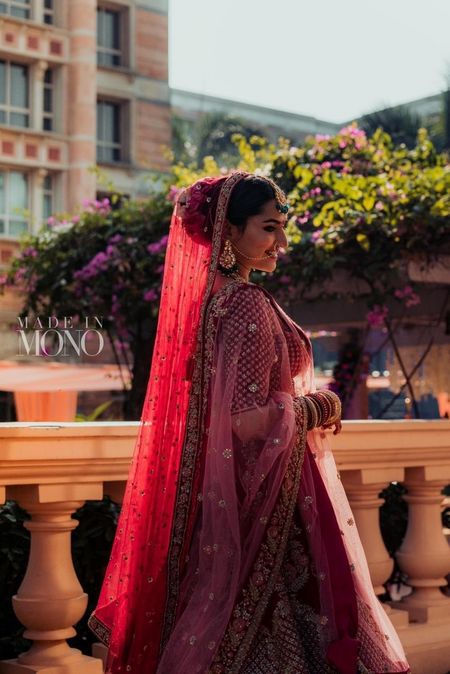 A bride in a red lehenga and flowers in her hair