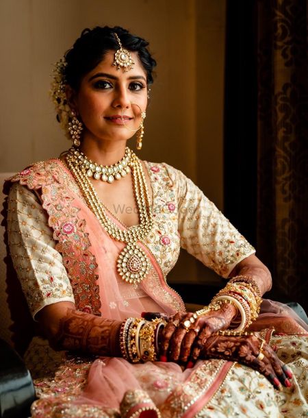 Bride wearing a white and pink lehenga.