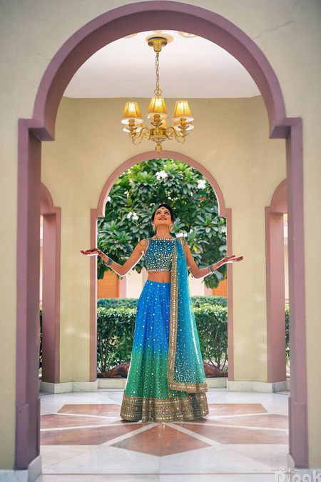 Blue and turquoise ombre lehenga with mirror work and gold border
