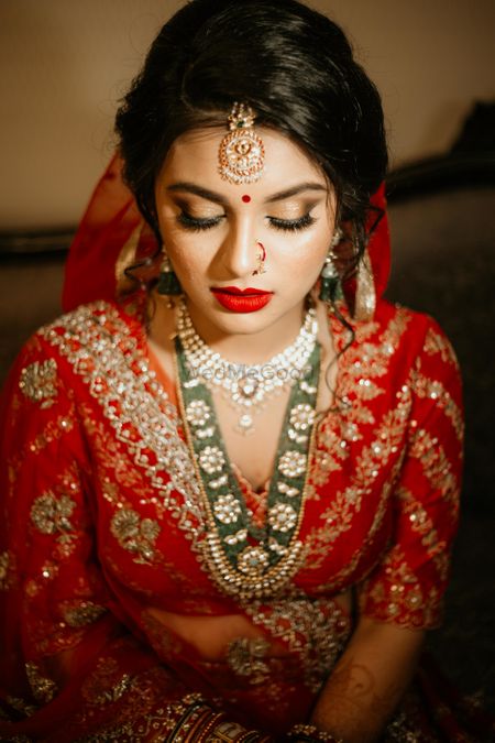 Bridal makeup with red lehenga and contrasting jewellery 