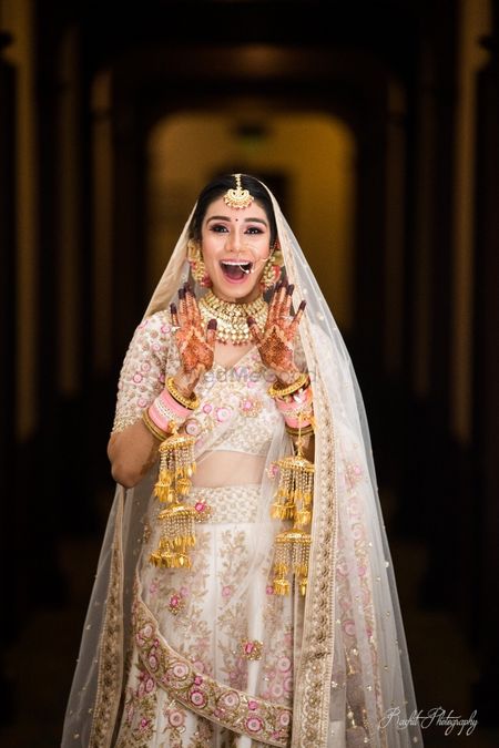 Happy and excited bride in white lehenga shot