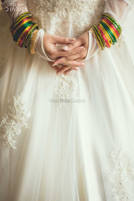 Green and yellow bangles over white gown
