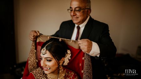 Bride with father placing dupatta on her head