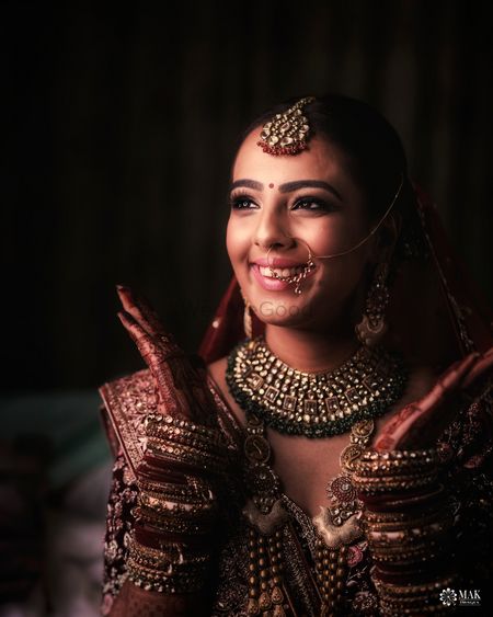 Photo of A happy bride smiling for the camera on her wedding day