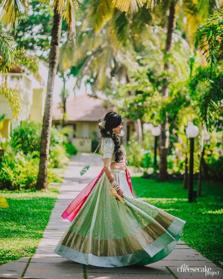 Photo of A bride twirling in her pastel green lehenga.