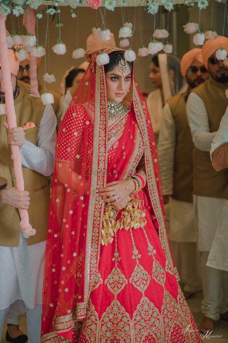 Bride entering with phoolon ki chadar with hanging roses 