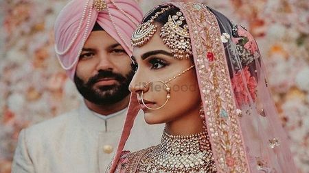 Photo of Sikh couple in light pink outfits and unique jewellery