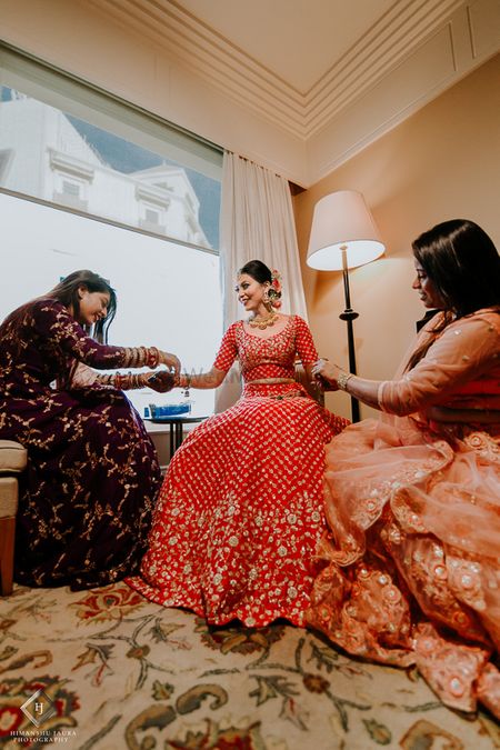 Photo of Bride with bridesmaids helping her get ready
