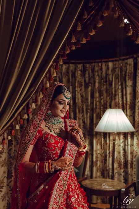 Photo of bridal entry portrait wearing green jewellery with red lehenga
