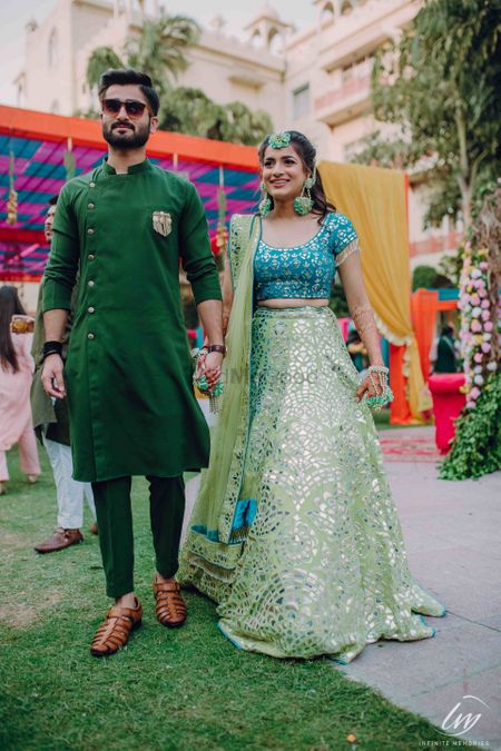 Bride and groom on mehendi in contrasting outfits of same shade