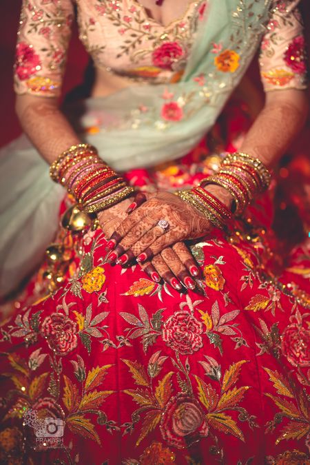 Bridal hands on floral embroidered lehenga 