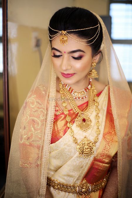 Beautiful bridal shot of a South Indian Bride with a dupatta as a veil. 