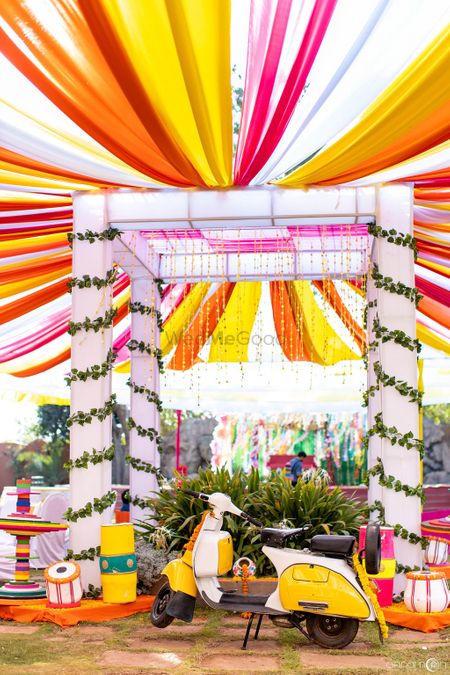 Colorful mehendi decor with drapes and props