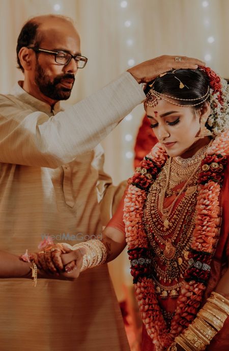 Photo of A south Indian bride during her wedding ceremony in a kanjeevaram and layered, temple jewelery