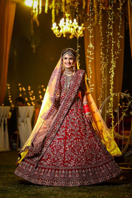 A pretty bride twirling in her beautiful red lehenga. 