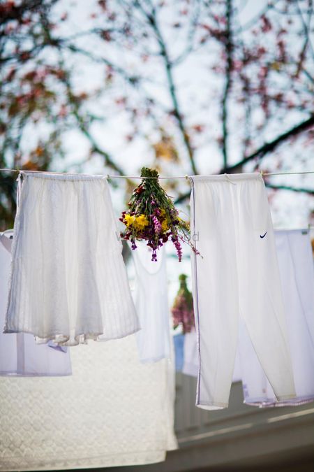 Super creative DIY decor with white clothes on a clothesline and floral bunches interspersed