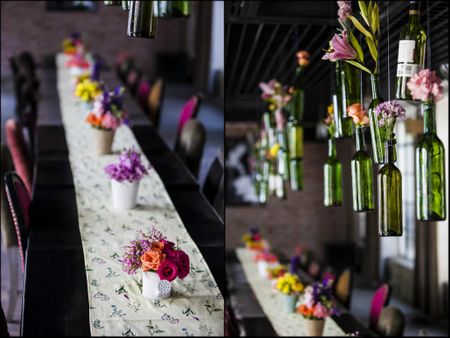 bottles with flowers hanging from ceiling over table