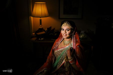 Photo of Bride in red and green lehenga for her wedding