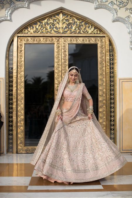 A stunning bride entering the room flaunting her fabulous lehenga. 