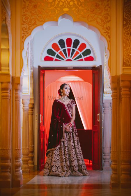 Bride in velvet lehenga and dupatta in maroon