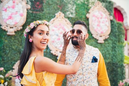 Cute mehendi couple shot with bride and groom fooling around