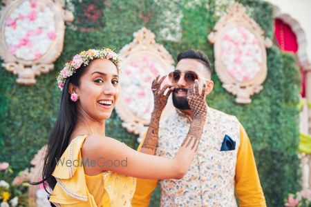 Cute mehendi couple shot with bride and groom fooling around