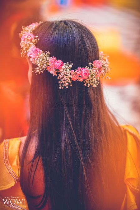 A bride to be flaunting a floral tiara on her mehndi