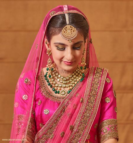 Photo of Fuschia Pink bride with maang tikka