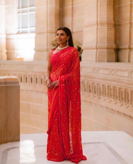 A friend of the bride in a sheer red saree