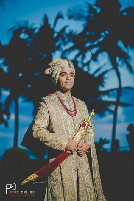 A groom dressed in gold embroidered sherwani