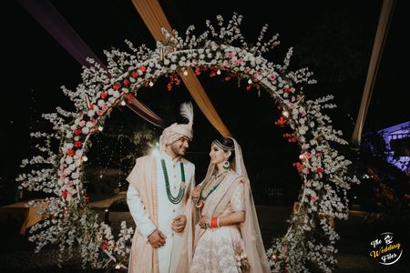 Photo of Couple portrait against floral archway