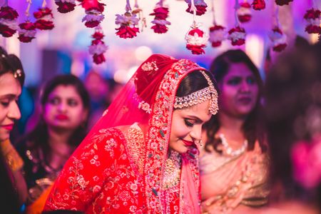 Bridal portrait in red under phoolon ka chadar