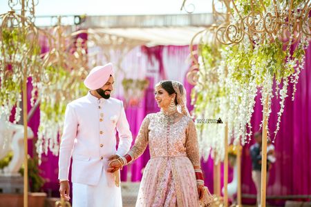 Coordinated sikh bride and groom wearing light pink outfits