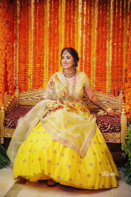 Photo of A bride to be in a yellow lehenga for her mehndi ceremony