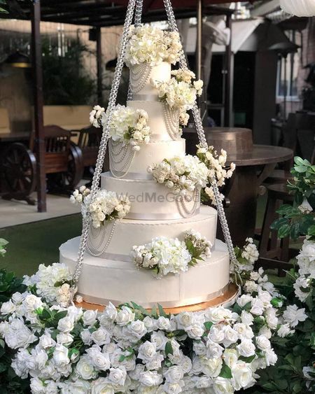 White wedding cake on a swing with florals 
