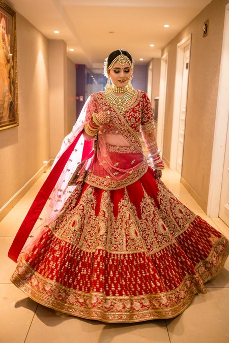 Bride in a heavy red and gold bridal lehenga