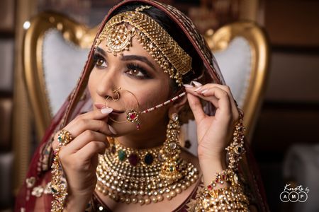 Photo of Heavy bridal mathapatti necklace and earrings with maroon lehenga