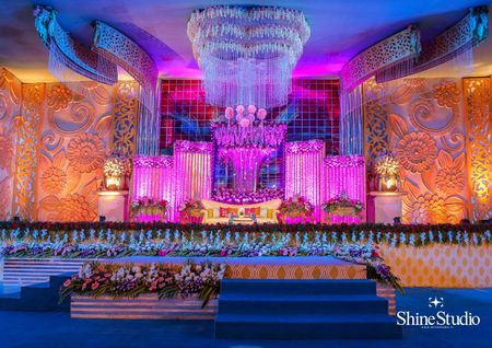 Elaborate stage decor for wedding in orange and purple