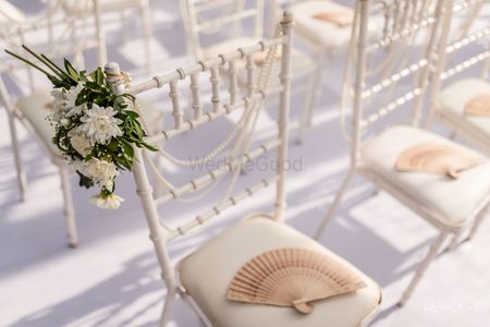 Summer wedding favour idea for guests with fans on chairs