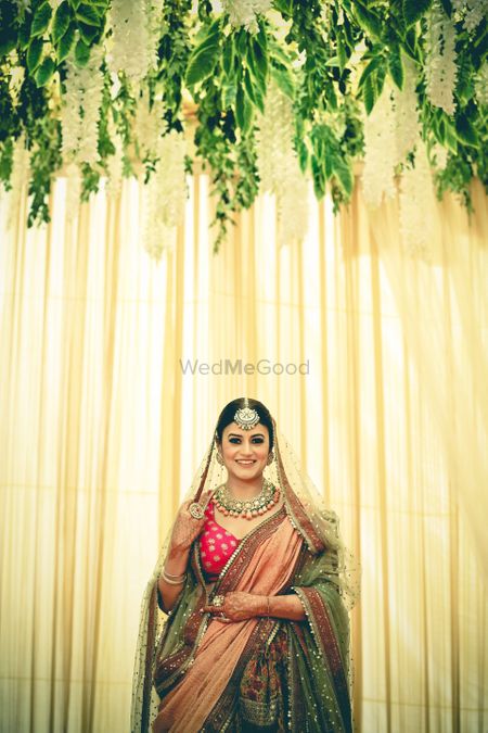 A bride in a multicolored lehenga with an oversized mangtikka 