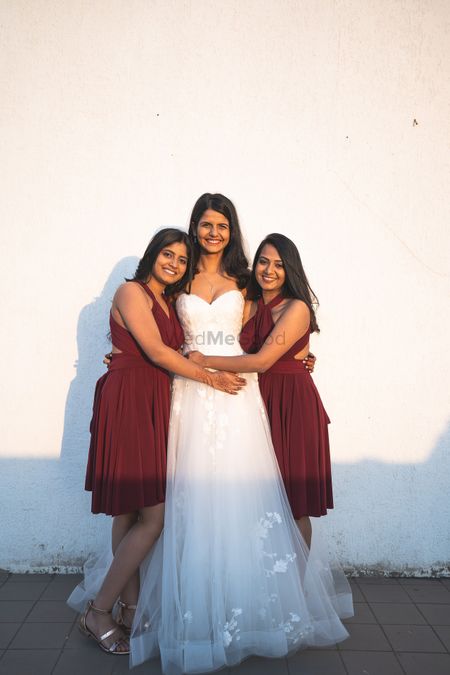 A bride with her bridesmaid in matching bridesmaid dresses. 