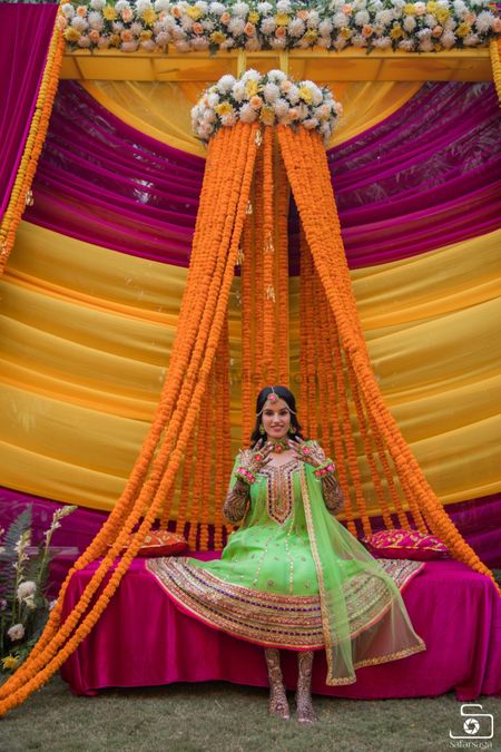 A bride in a parrot green mehndi outfit