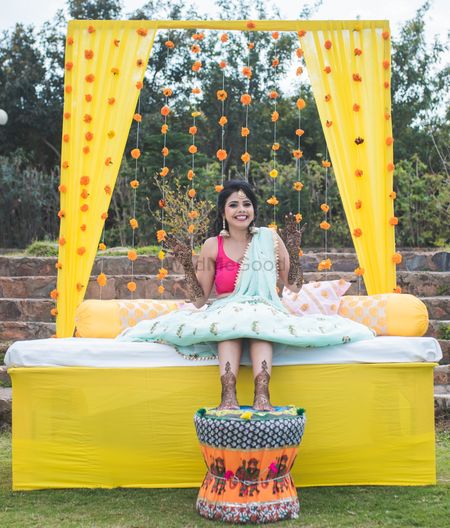 Photo of Mehendi bridal seat with marigold decor