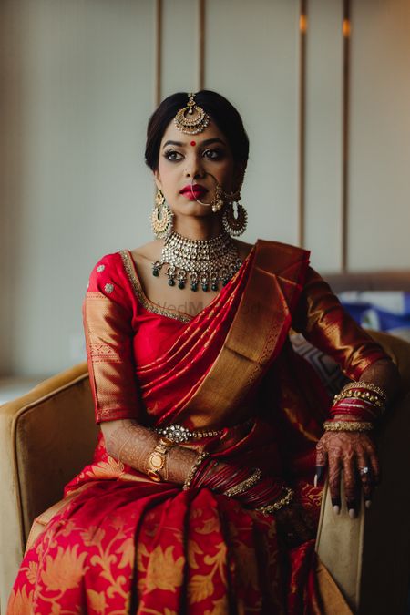 South indian bridal look in red kanjivaram and green jewellery