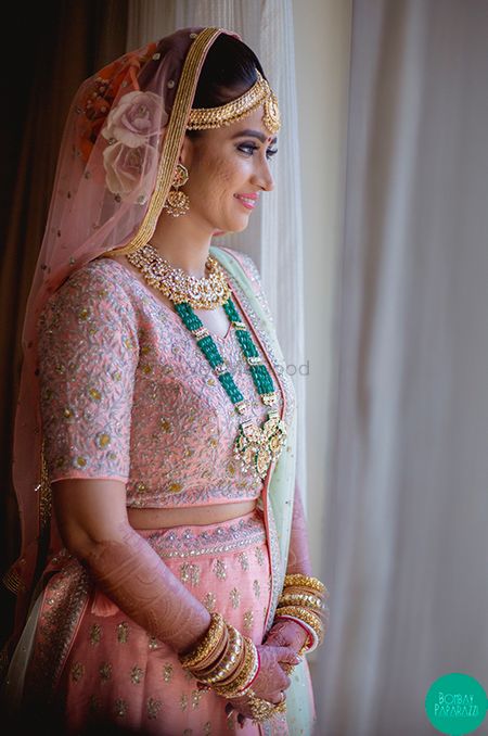 Photo of A bride in pink lehenga with contrasting jewellery