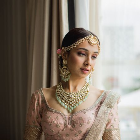 A bride in a pink blush outfit getting ready