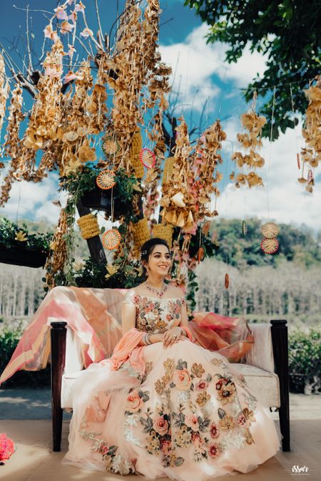 Mehendi bridal seat decor with gota and bride in pastel floral lehenga