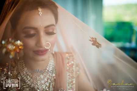 bridal portrait with a veil out of peach dupatta